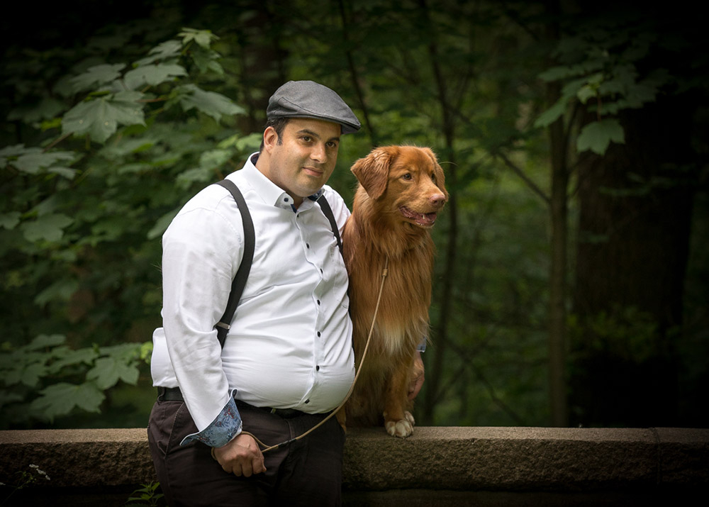 Ein Mann und sein Hund an einer Mauer stehend, im Wald