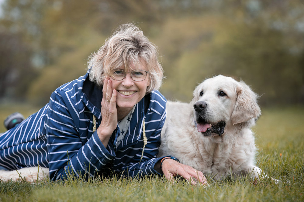 Doppelporträt Frau mit ihrem Hund im Gras
