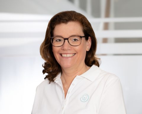 Portrait  Zahnärztin, die in die Kamera schaut, in ihrer Praxis